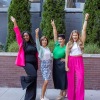 group of women outdoors with their hands in the air